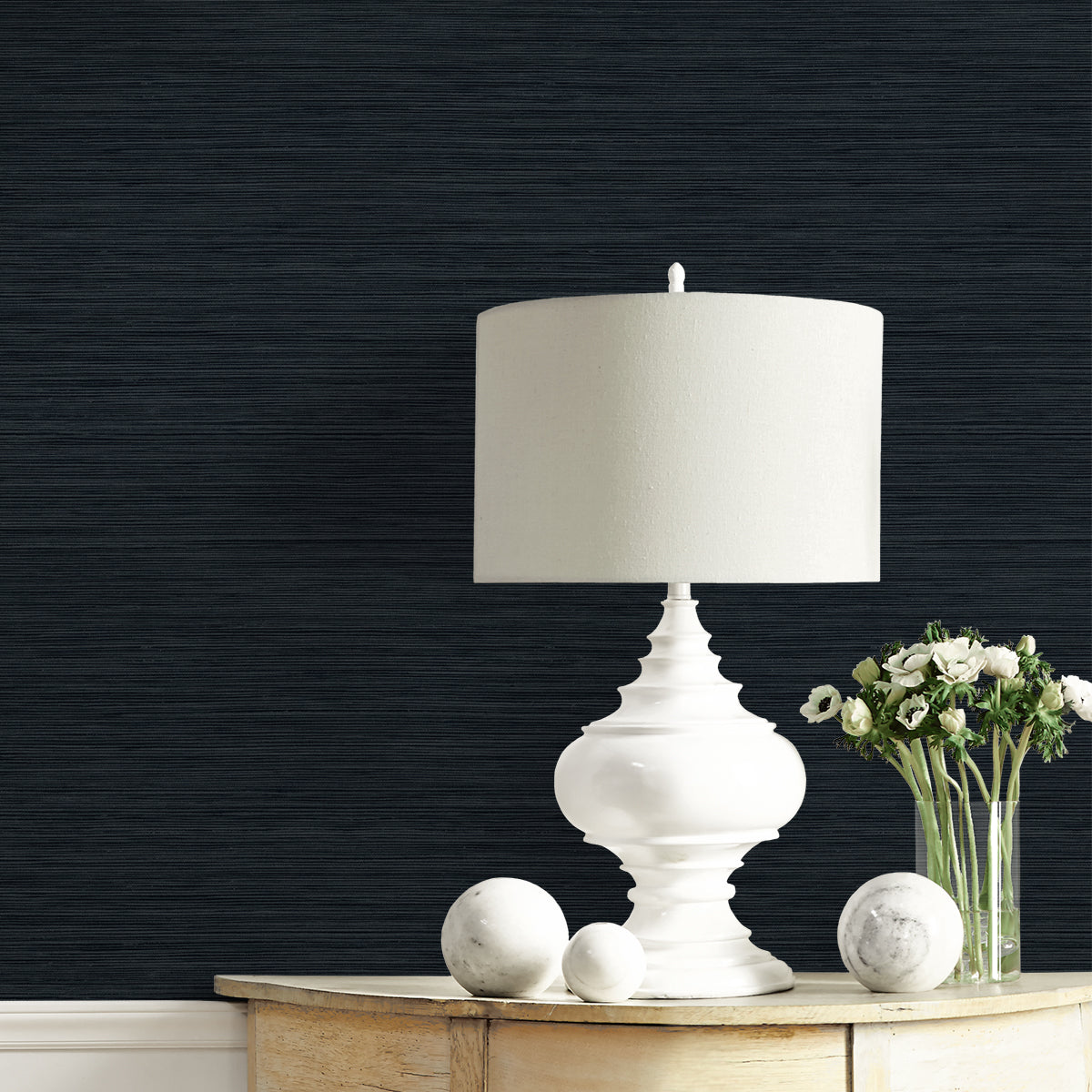 White table lamp on a wooden surface with a dark textured wall background