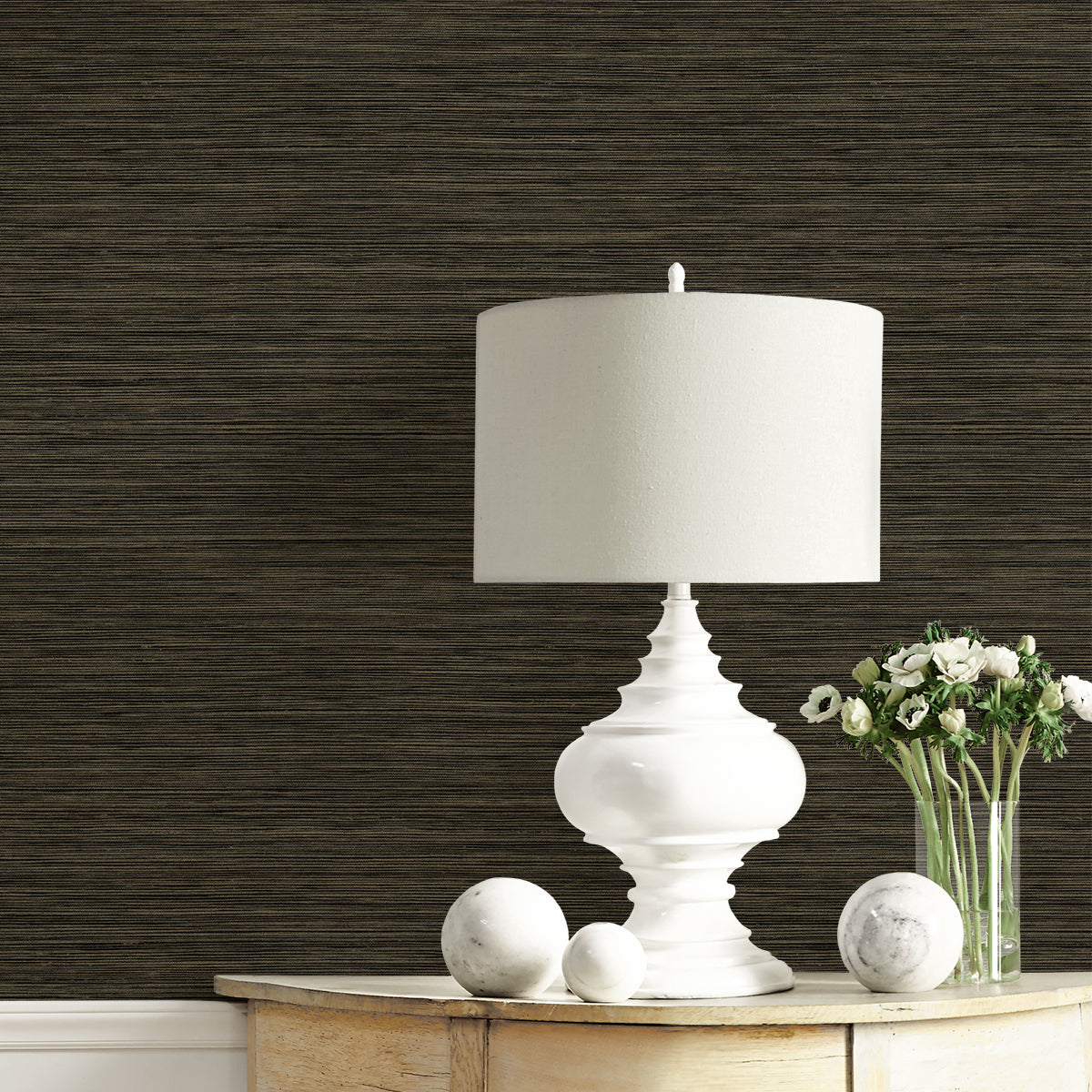 White table lamp on a wooden surface with dark textured wall in the background