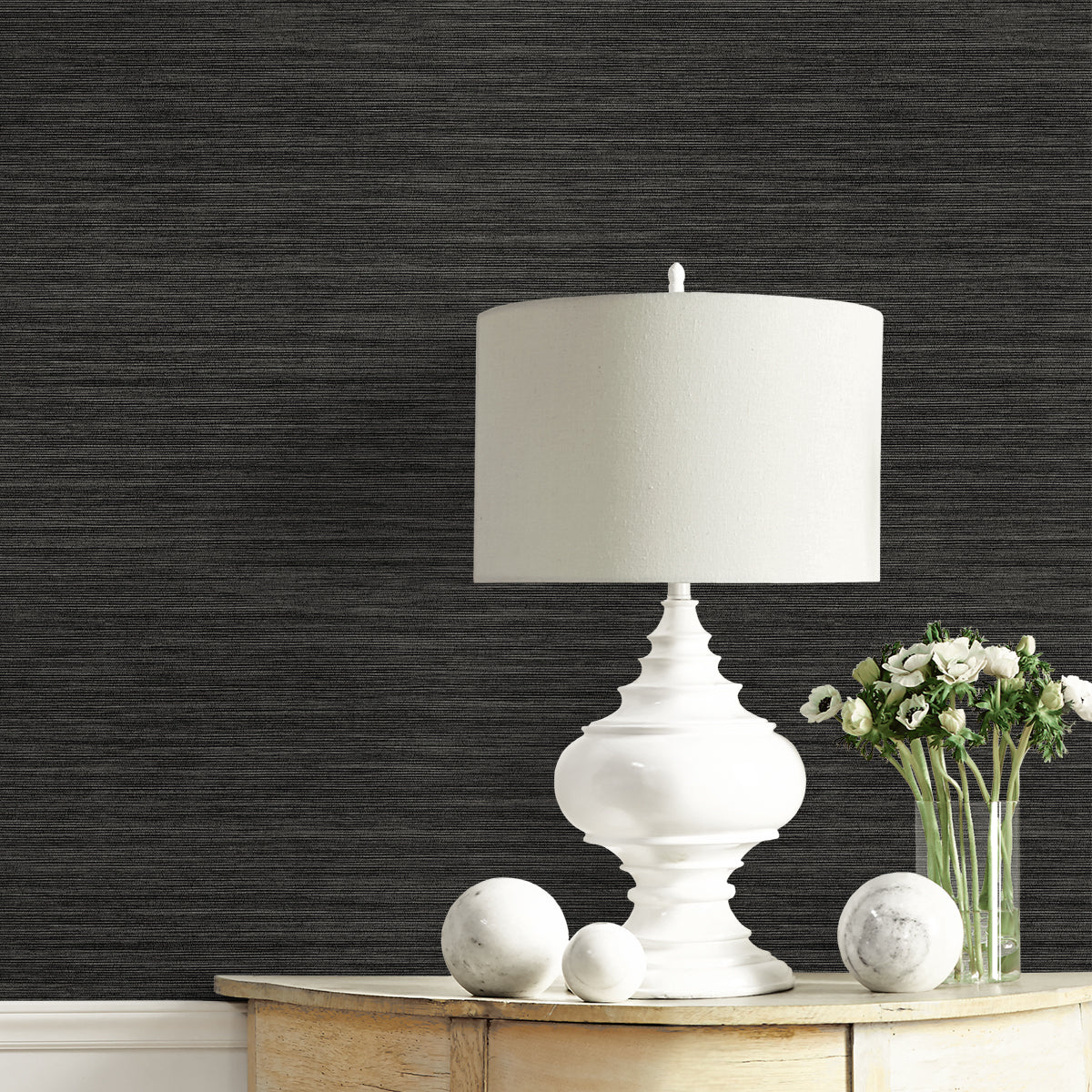 White table lamp on a wooden surface with dark textured wallpaper in the background