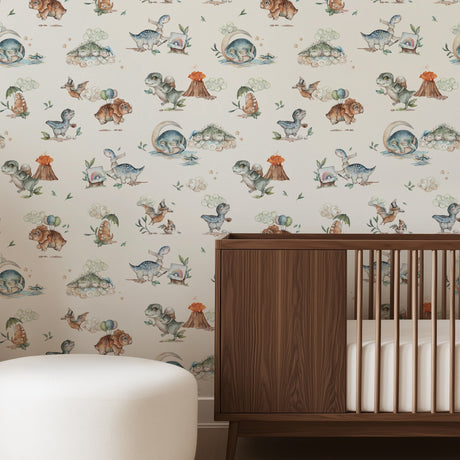 Nursery room with wooden crib, white ottoman, and wallpaper with dinosaur designs.