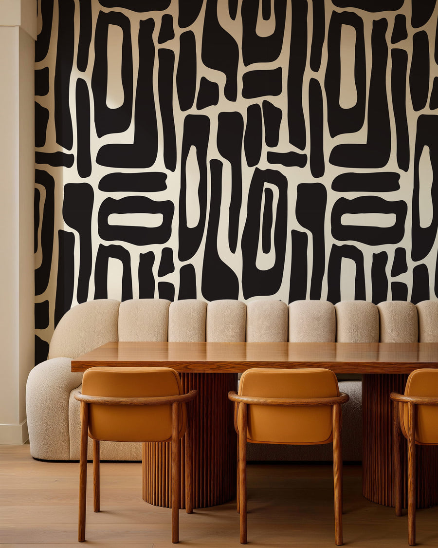 Dining area with a Modern Abstract Black and White Geometric Wallpaper, beige sofa, wooden table, and orange chairs.