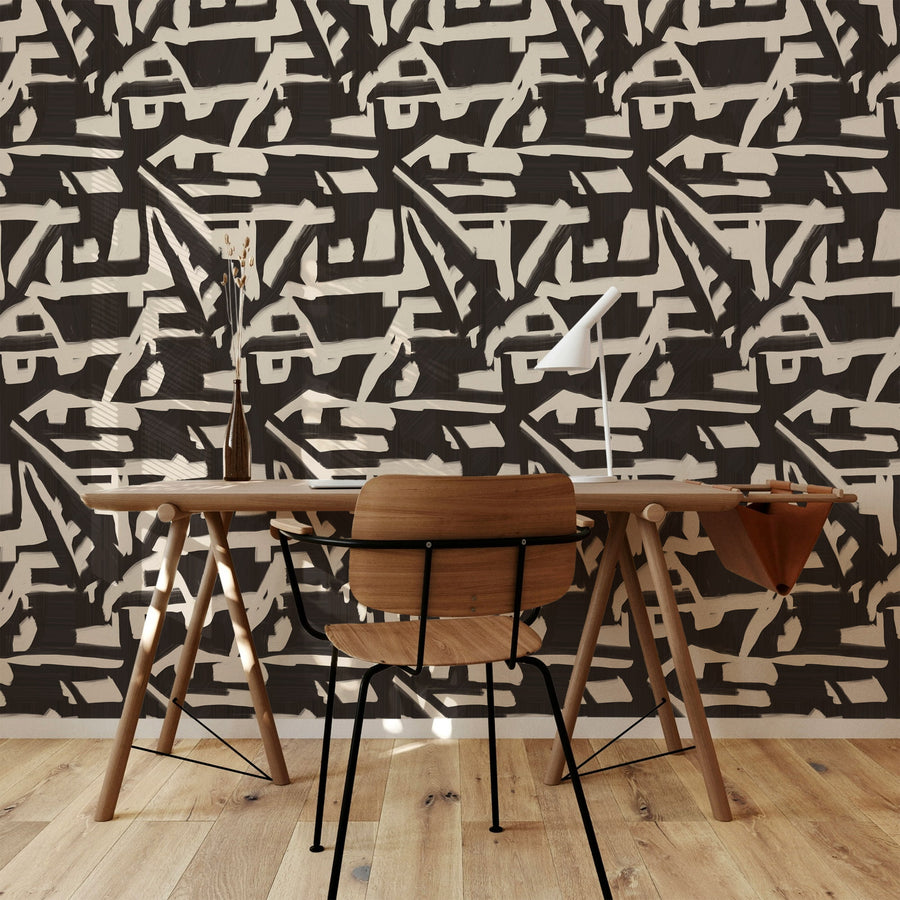 Modern room with wooden desk and chairs against a black and white abstract wallpaper