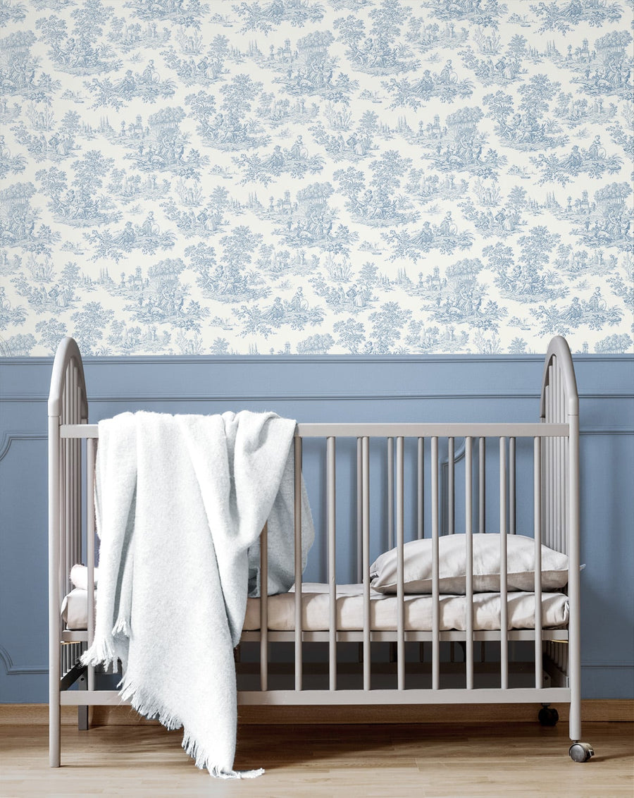 Nursery with a crib against a wall with blue floral wallpaper