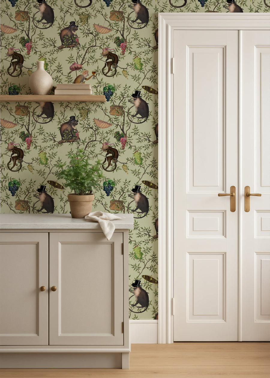 Room interior with decorative wallpaper featuring monkeys and plants, a white door, and wooden floor.