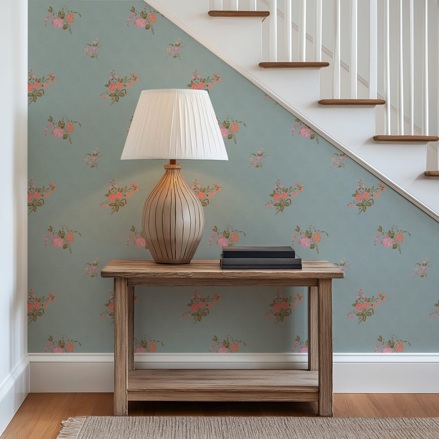 Wooden table with a lamp against a wall with Vintage Heirloom Floral Bouquet Wallpaper in Blue