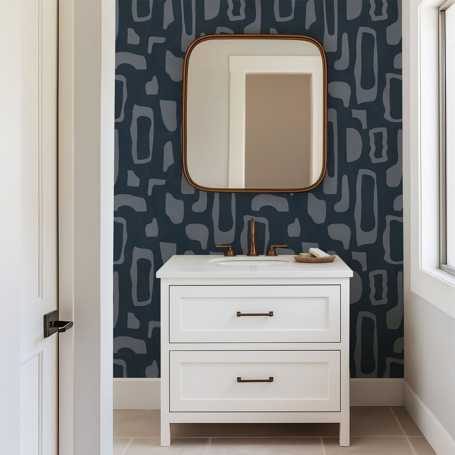 Bathroom with white vanity arched-top framed mirror and gold faucet featuring Abstract Organic Shapes Wallpaper Navy Slate Blue by Petra Kohlmayr