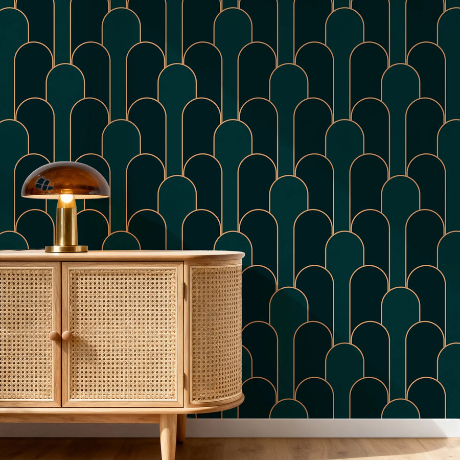 Emerald green and gold Art Deco arch wallpaper behind a cane sideboard with a gold mushroom lamp