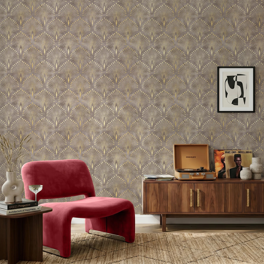 Art Deco fan wallpaper in brown and gold behind a red velvet accent chair and vintage wood credenza