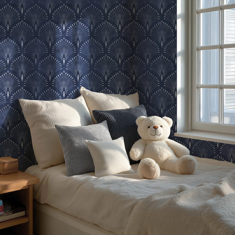 Art Deco fan wallpaper in navy blue in a bedroom with cream bedding and cushions