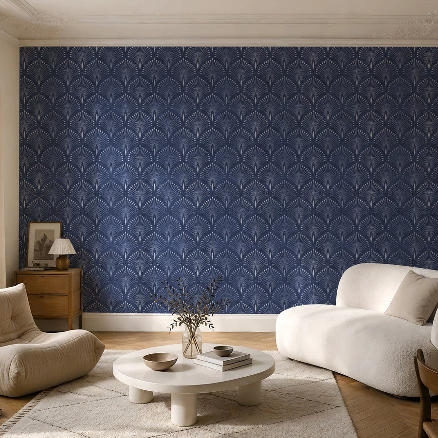 Navy blue Art Deco fan wallpaper in a living room with a cream armchair and round coffee table