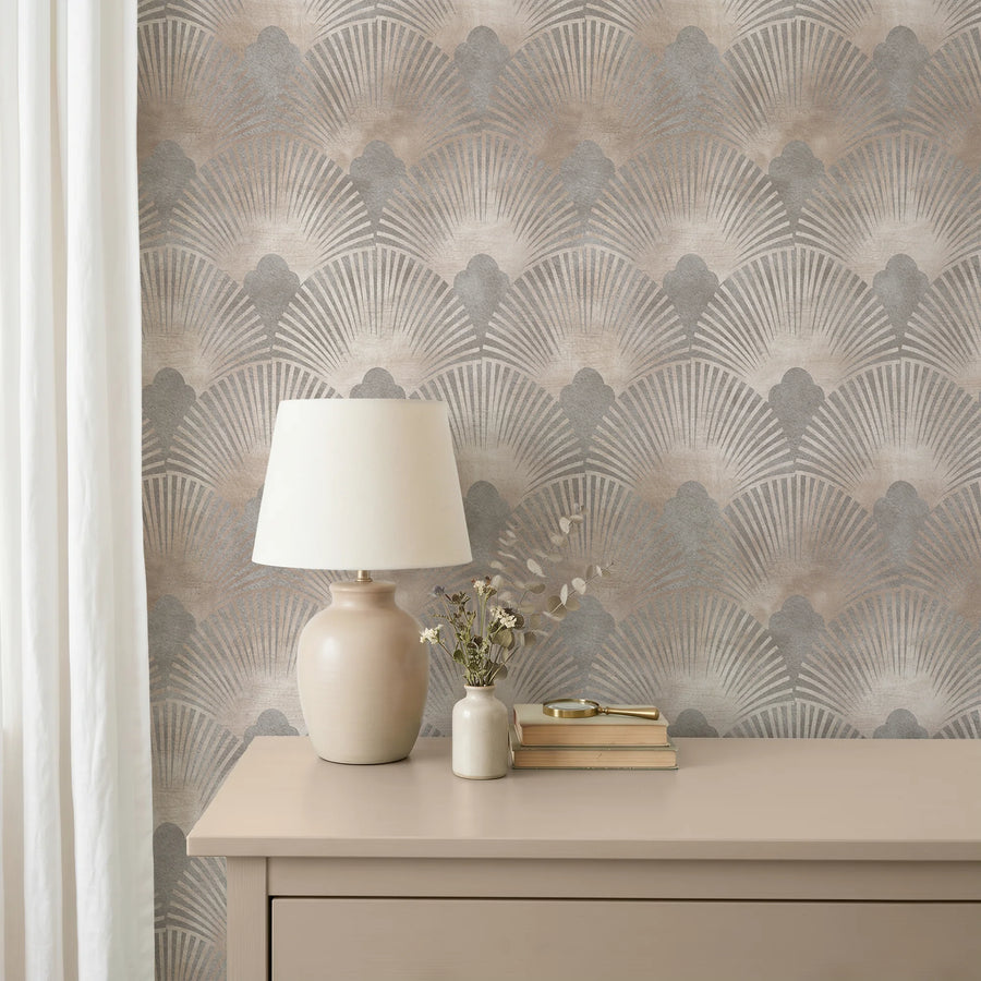 Art Deco scallop wallpaper in beige and gray behind a dresser with a ceramic lamp and dried stems