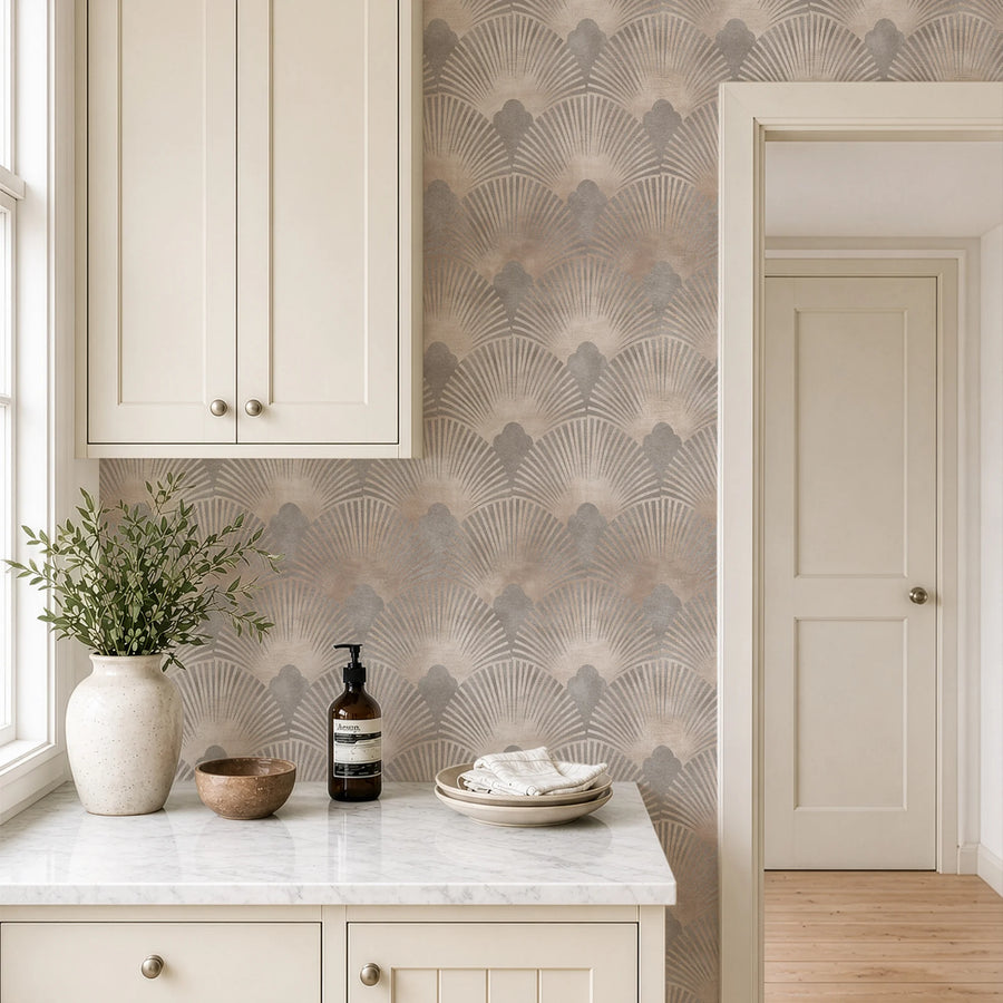 Beige and gray Art Deco scallop wallpaper on a wall beside cream cabinetry and a stone countertop
