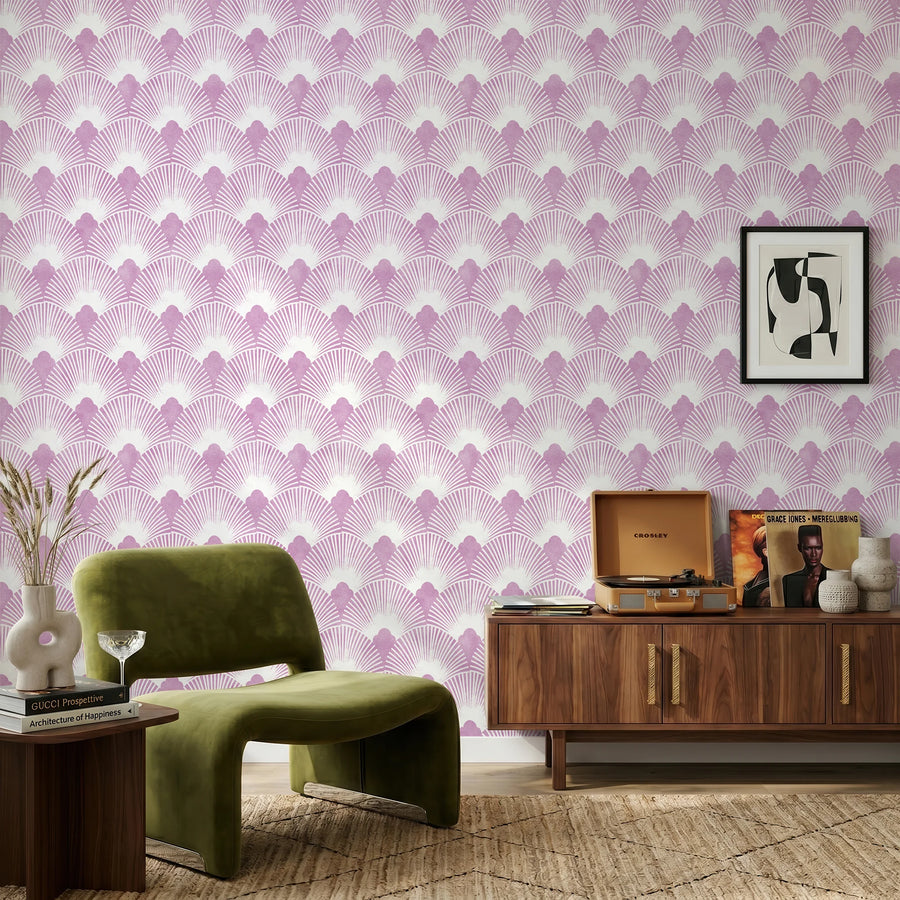 Pink mauve Art Deco scallop wallpaper in a living room with a green velvet chair and wood credenza