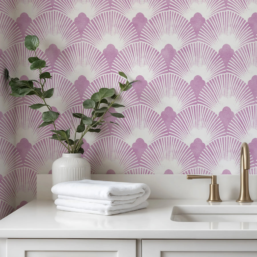 Pink mauve Art Deco scallop wallpaper above a white vanity with folded towels and a plant