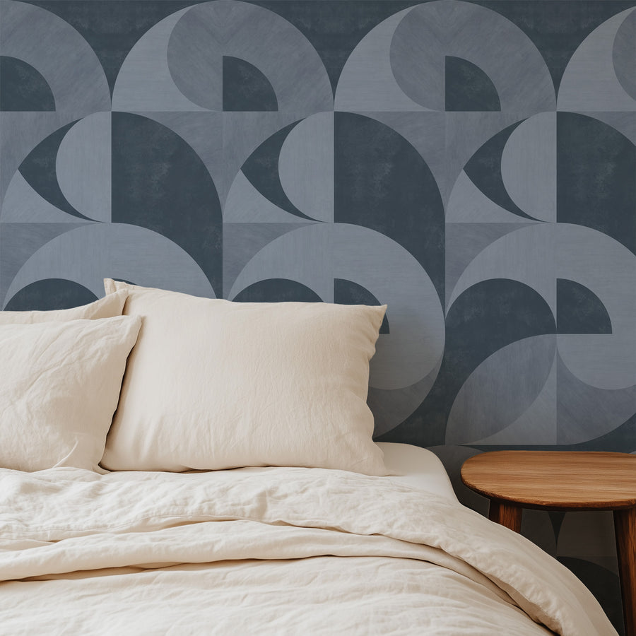 Lounge with cream boucle curved armchairs featuring Bauhaus Mid-Century Arch Wallpaper Slate Blue Grey by Petra Kohlmayr