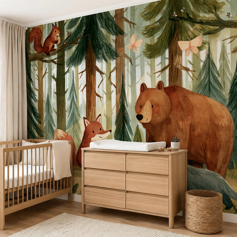 Brown bear and fox pine forest mural behind a crib and wooden changing dresser