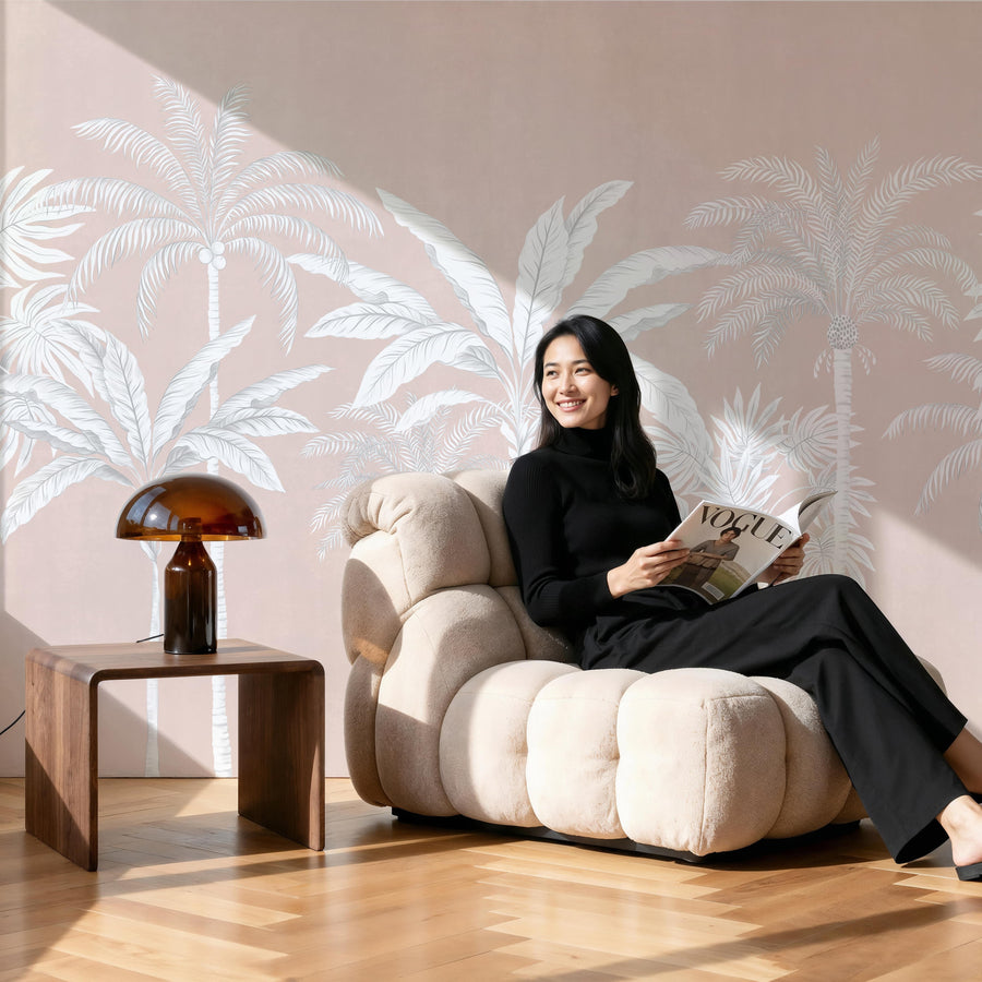 Blush pink palm tree wallpaper mural in a bedroom behind a low platform bed