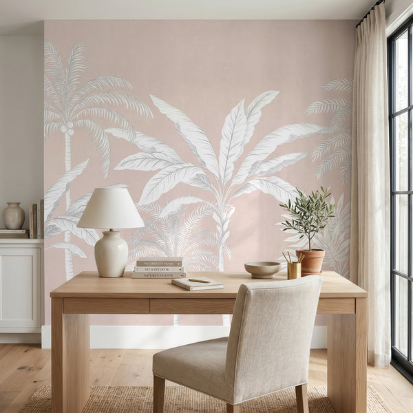 Blush pink palm tree mural in a home office behind a wood desk and lamp