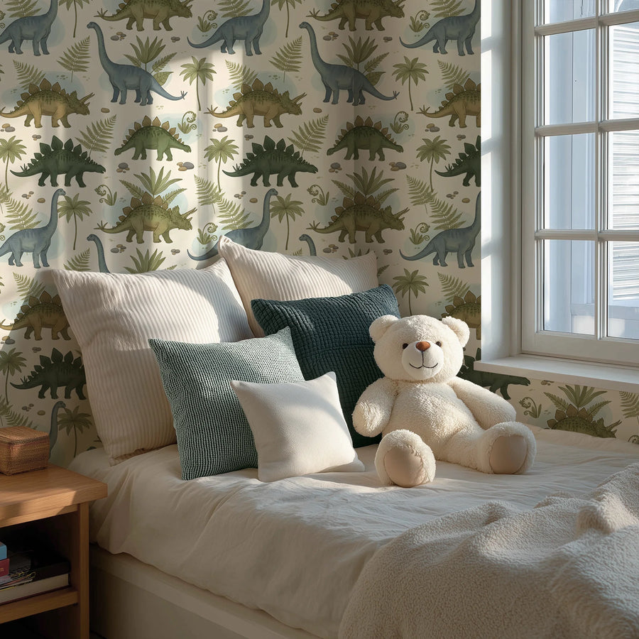 Botanical dinosaur wallpaper in sage and cream behind a bed with green pillows and a teddy bear by the window