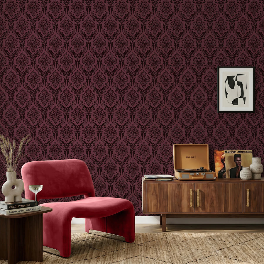 Burgundy damask wallpaper in a sitting room with a red accent chair