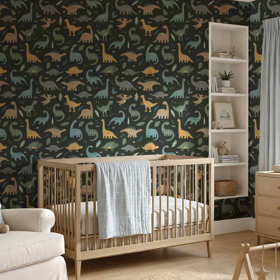 Cute dinosaur wallpaper on dark green behind a wooden crib and armchair