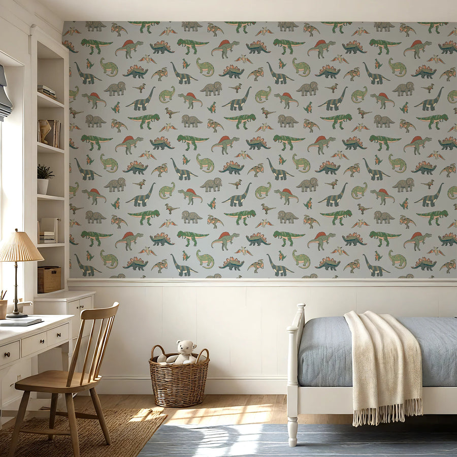 Cartoon dinosaur wallpaper in baby blue above white wainscoting in a kids bedroom with a desk