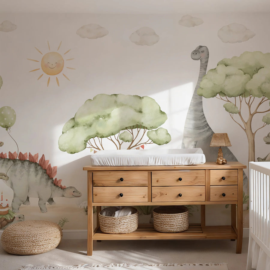 Baby dinosaur nursery mural behind a wooden dresser with woven baskets