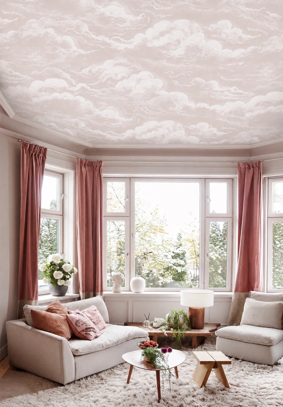 Dusty pink sky and clouds wall mural in a cozy living room
