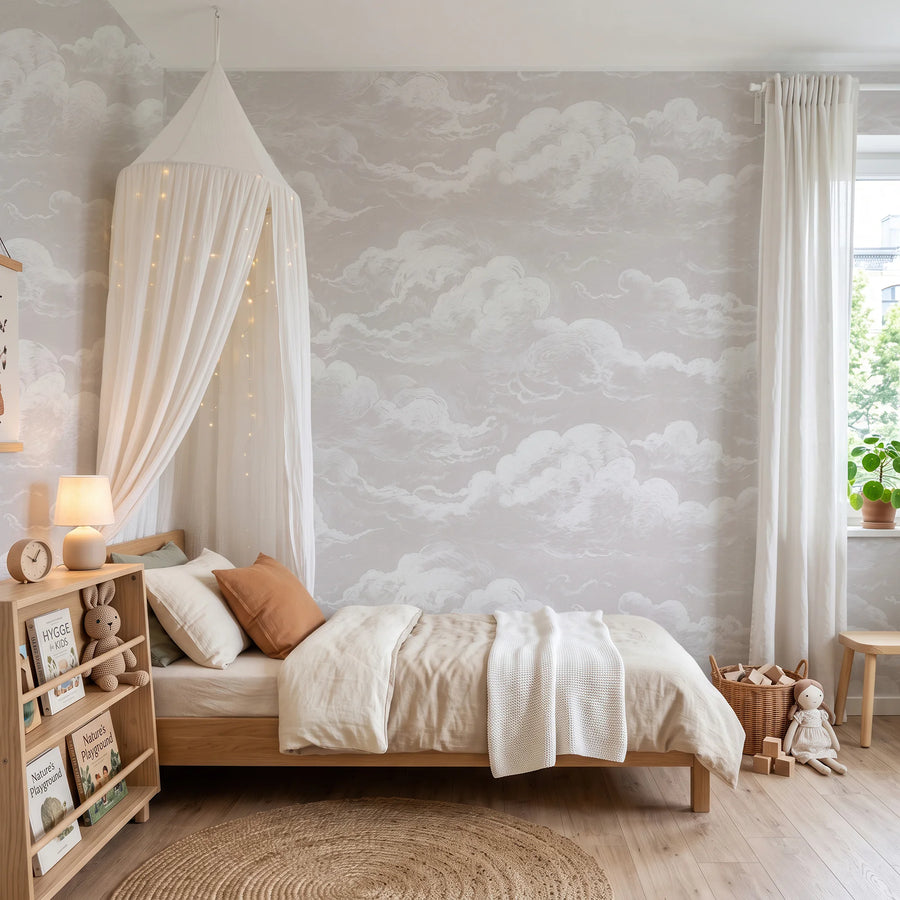 Dusty pink sky and clouds wall mural in a nursery with a canopy bed