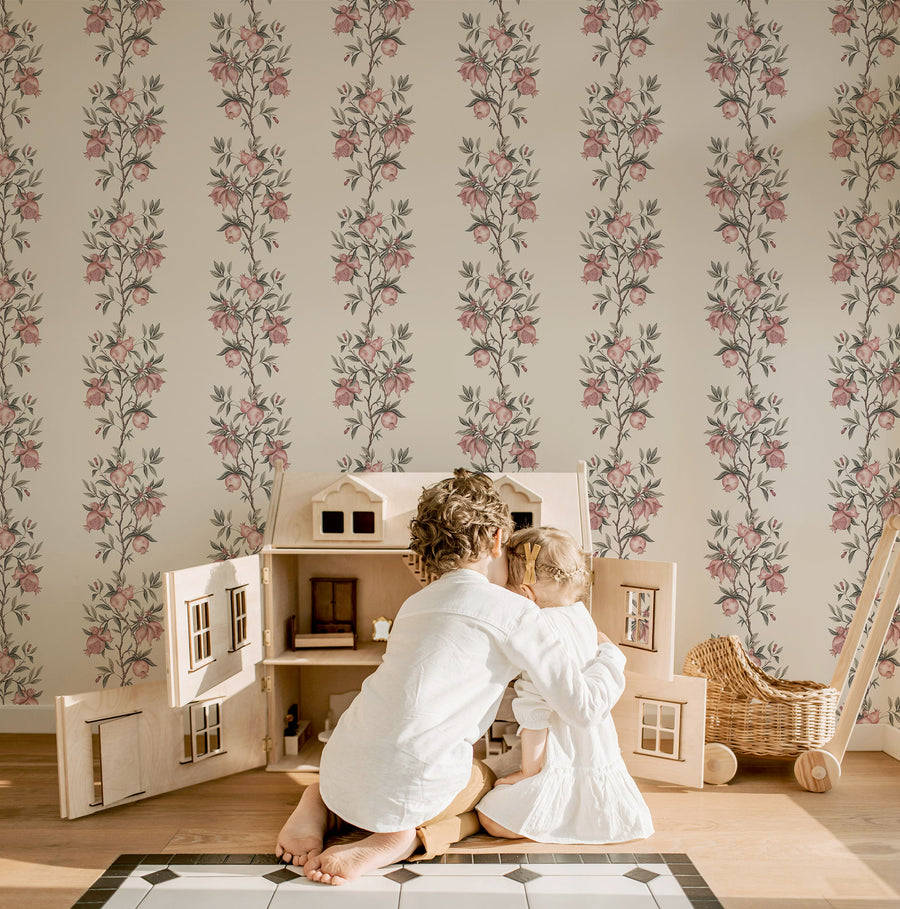 Playroom with child at wooden dollhouse and woven basket featuring Elodie Chinoiserie Pomegranate Wallpaper Beige by Maja Pitschmann