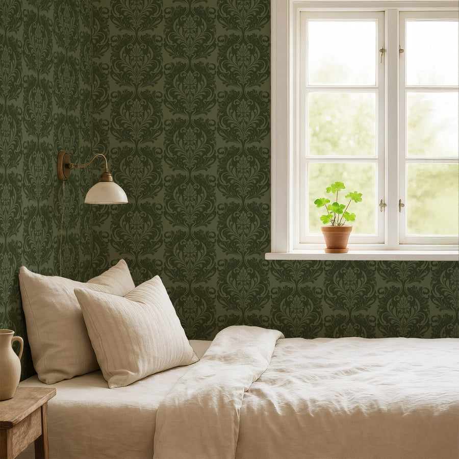 Green farmhouse damask wallpaper behind a bed with neutral linens