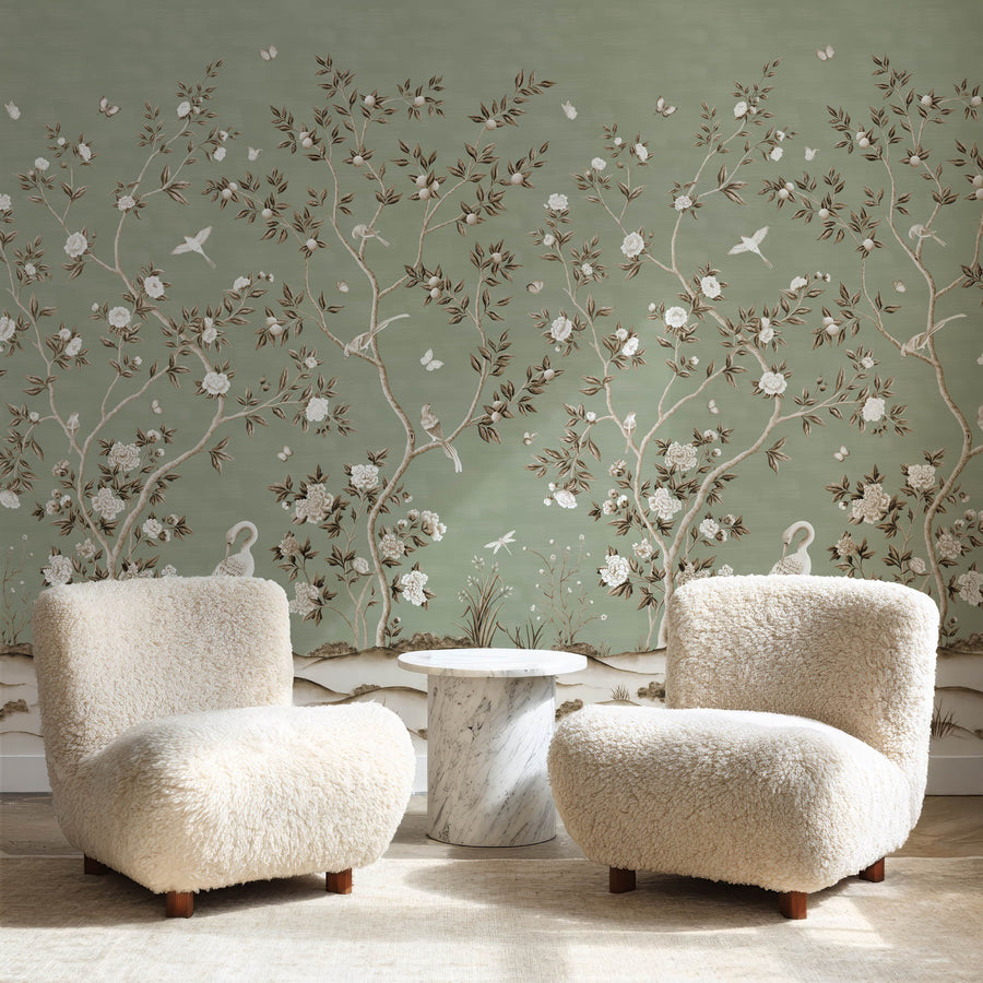 Lounge with two cream boucle chairs and side table featuring Green Chinoiserie Wallpaper Mural Birds Cranes accent wall