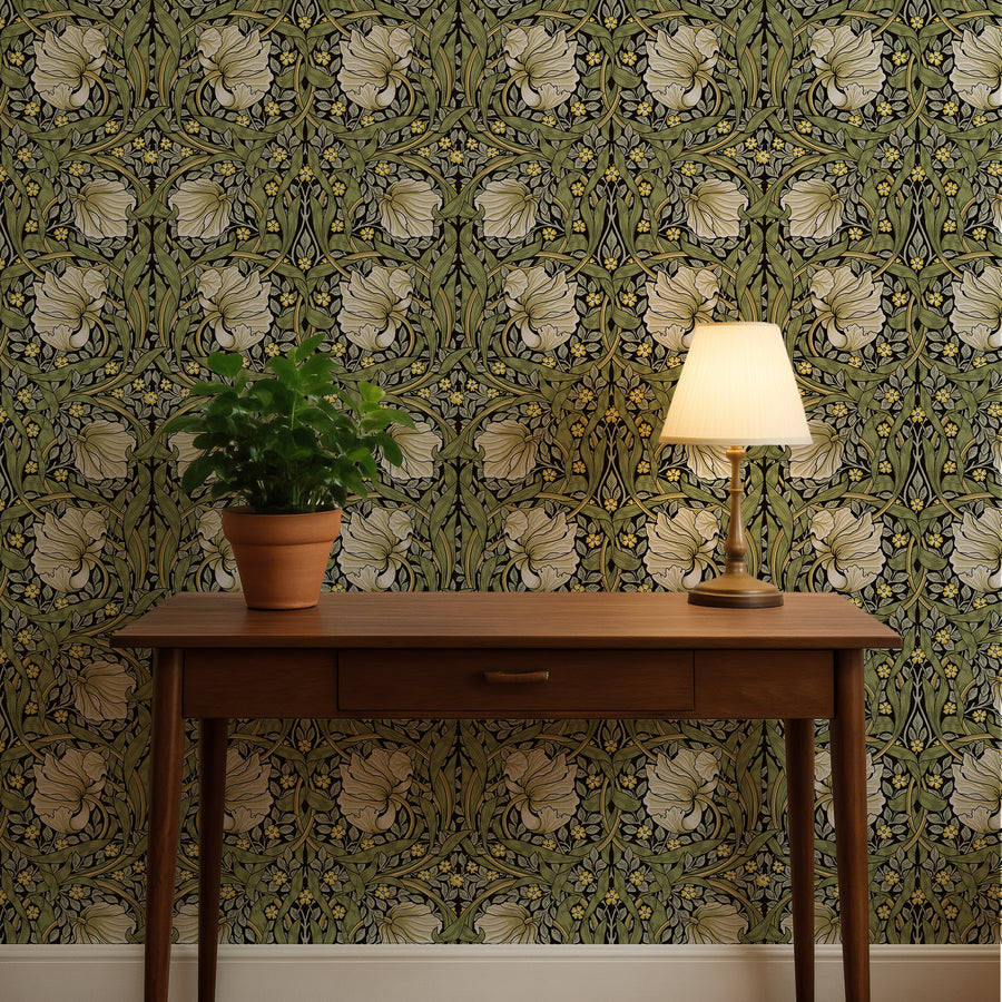 Green and cream William Morris Pimpernel wallpaper behind a wood console and table lamp