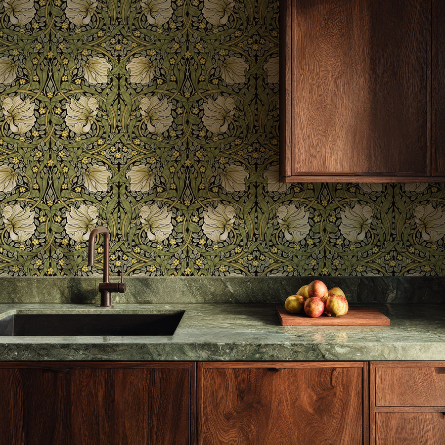 Green and cream William Morris Pimpernel wallpaper in a kitchen with walnut cabinets and green marble