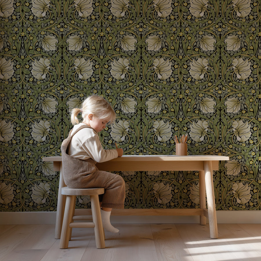 Green and cream William Morris Pimpernel wallpaper in a room with a child at a wood desk