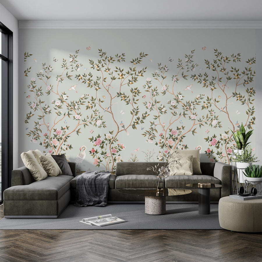 Light blue chinoiserie crane mural in a living room behind a grey sectional sofa
