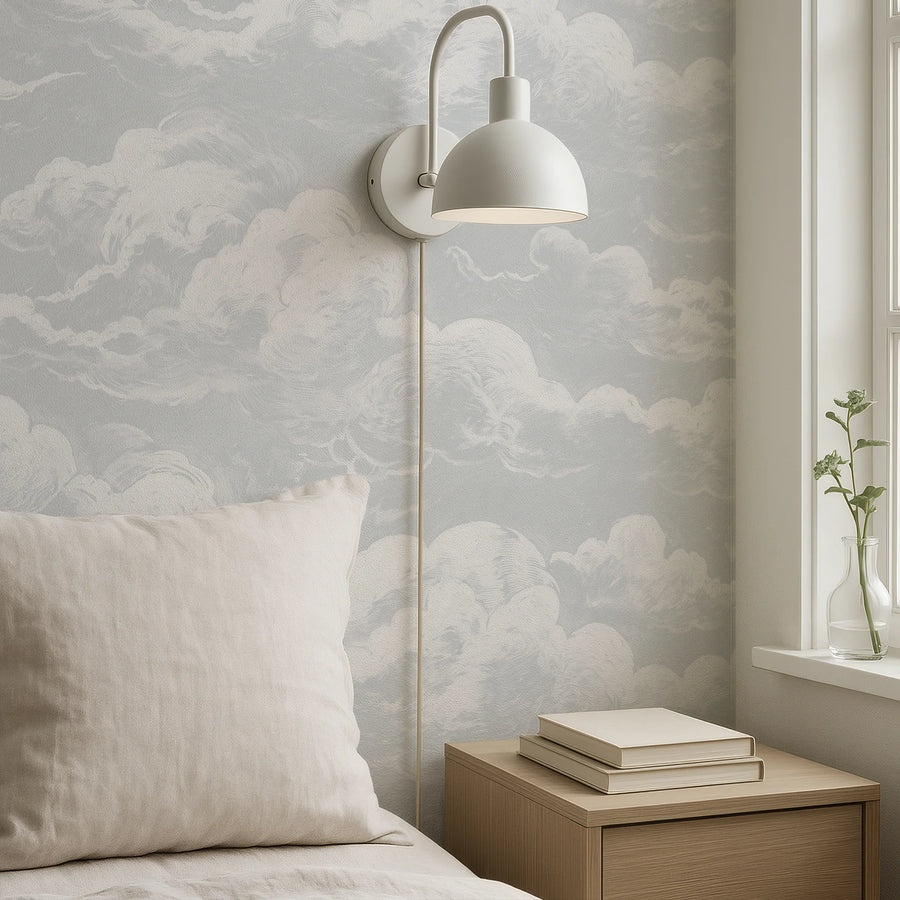 Light blue sky and clouds wall mural in a corner with a wall sconce