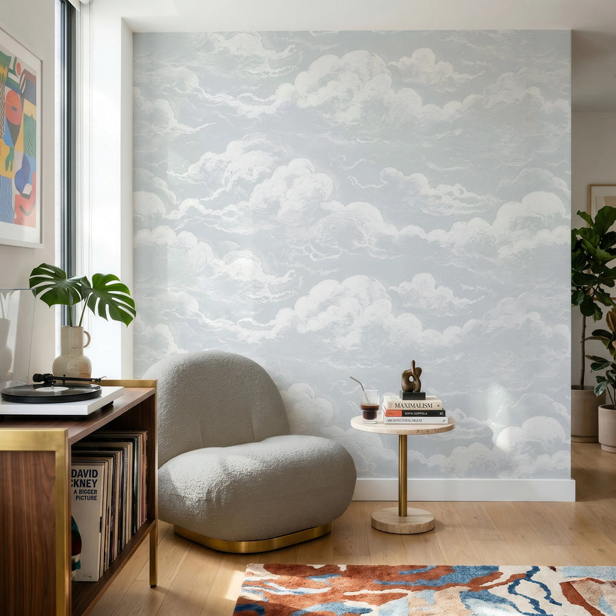 Light blue sky and clouds wall mural behind a reading chair