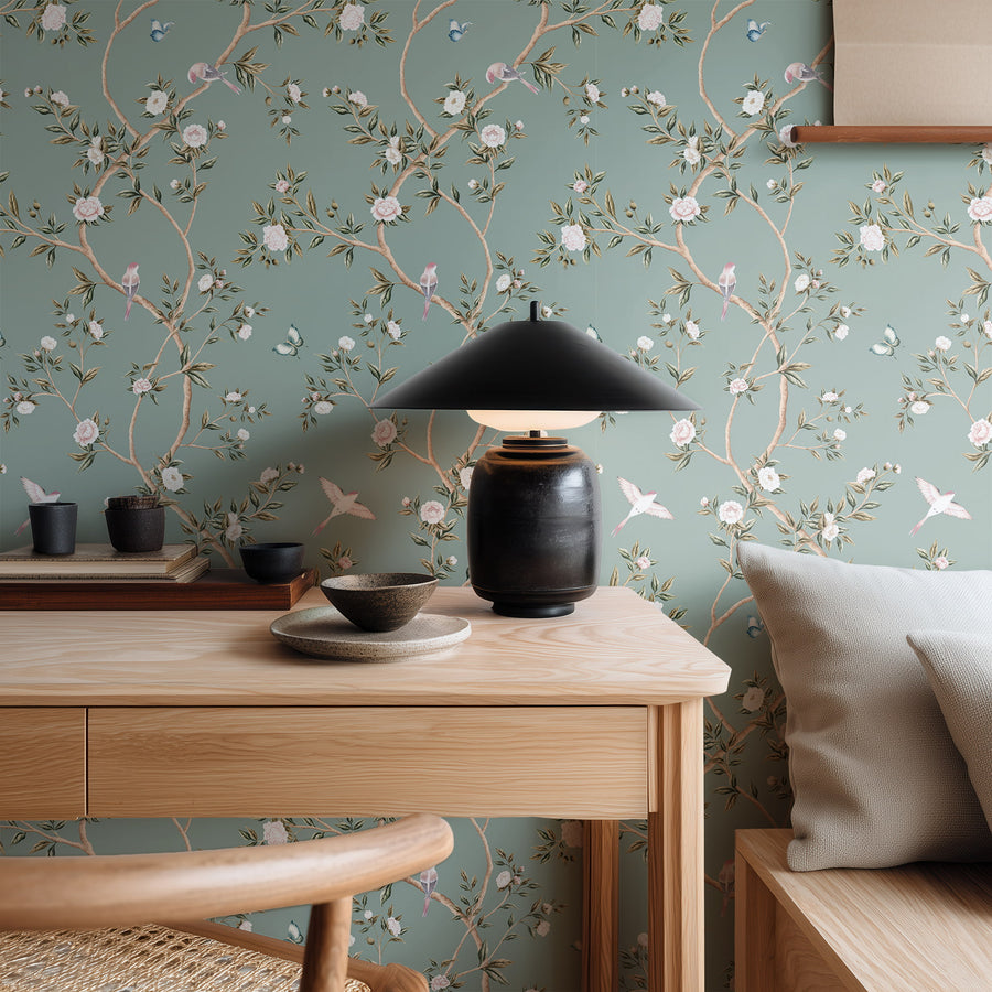 Dining area with wood table black table lamp and dark bowls featuring Light Green Chinoiserie Hemma Wallpaper Floral Garden Birds accent wall
