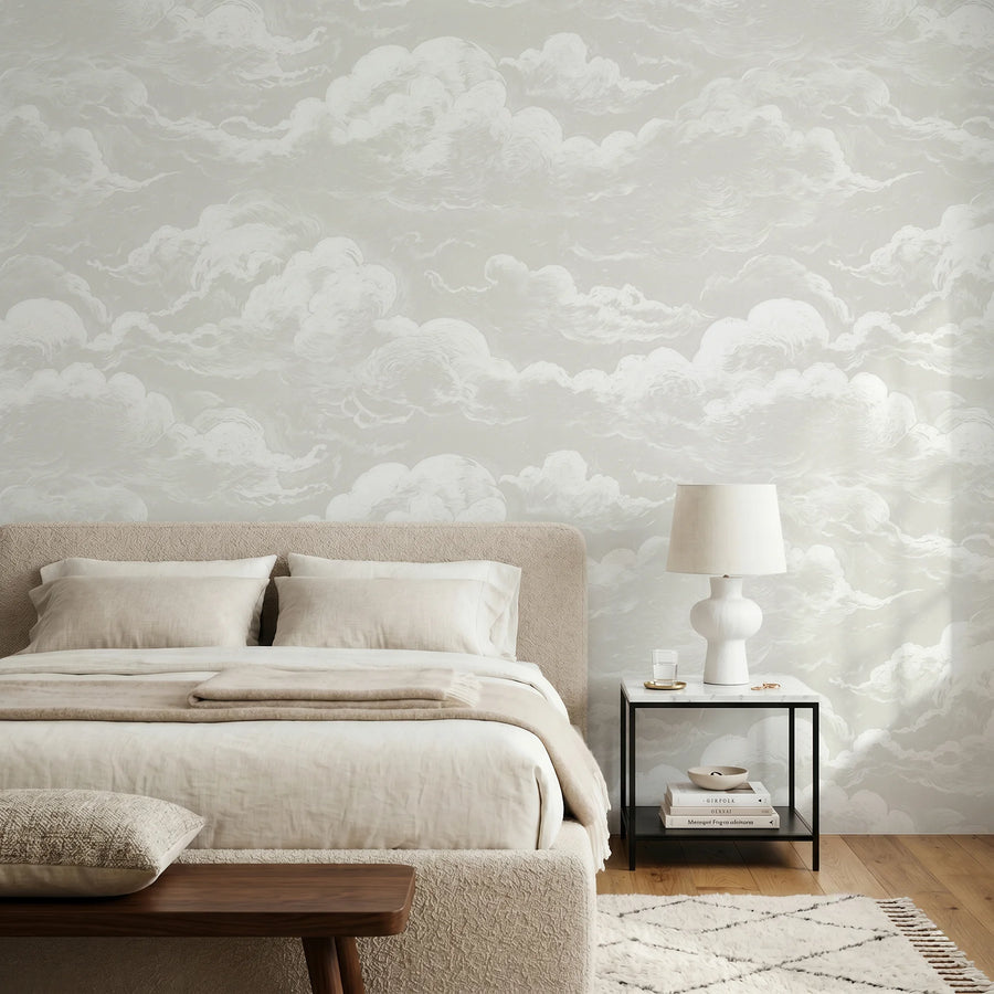Light grey sky and clouds wall mural in a bedroom with a neutral upholstered bed