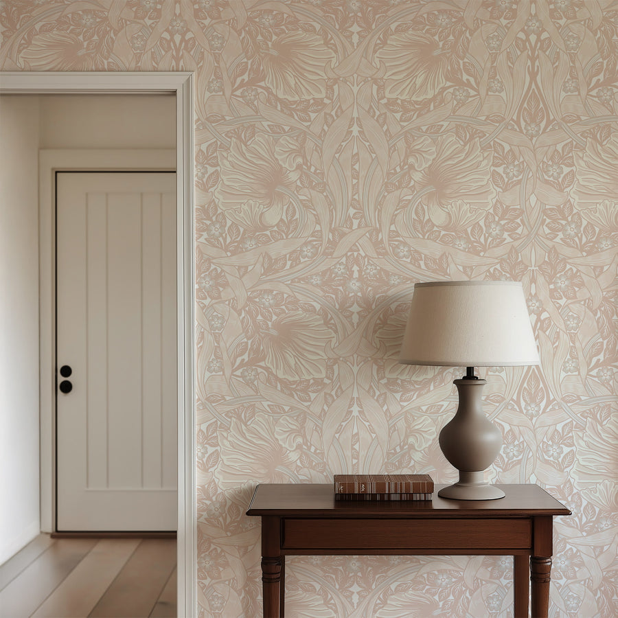 Light pink William Morris Pimpernel wallpaper behind a wood console and table lamp