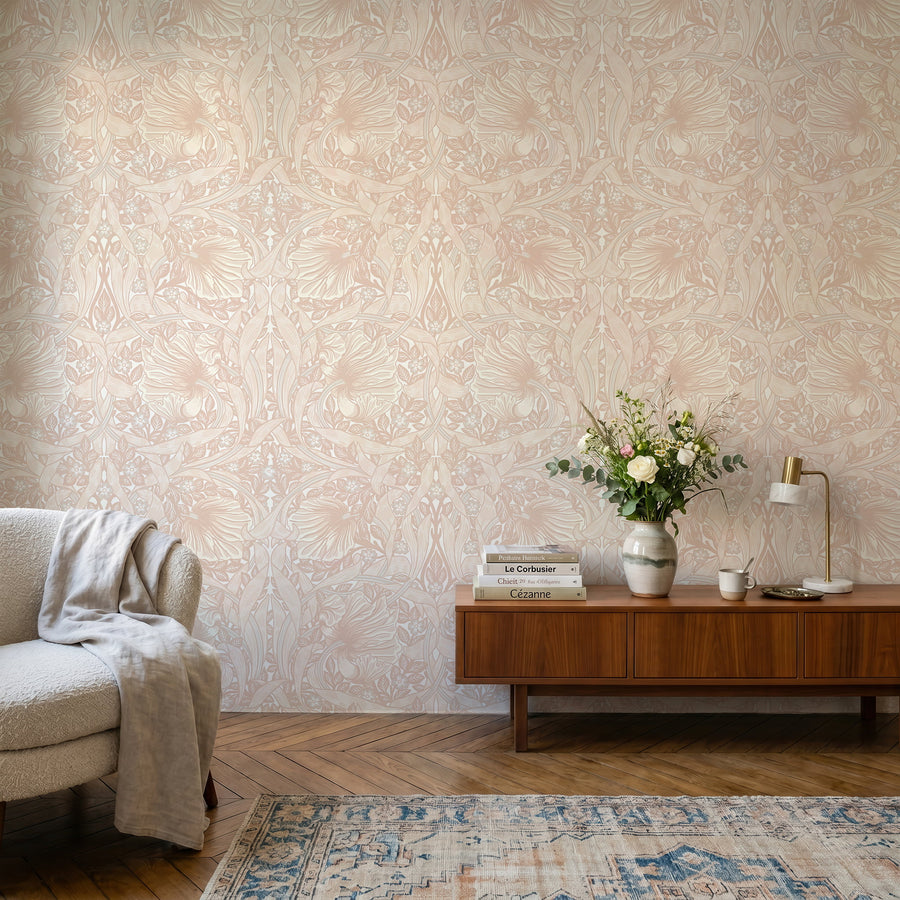 Light pink William Morris Pimpernel wallpaper in a living room with walnut credenza and cream chair