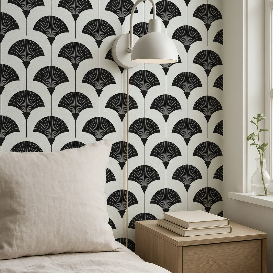 Minimalist black and white Art Deco fan wallpaper in a bedroom corner with a linen cushion and wall lamp