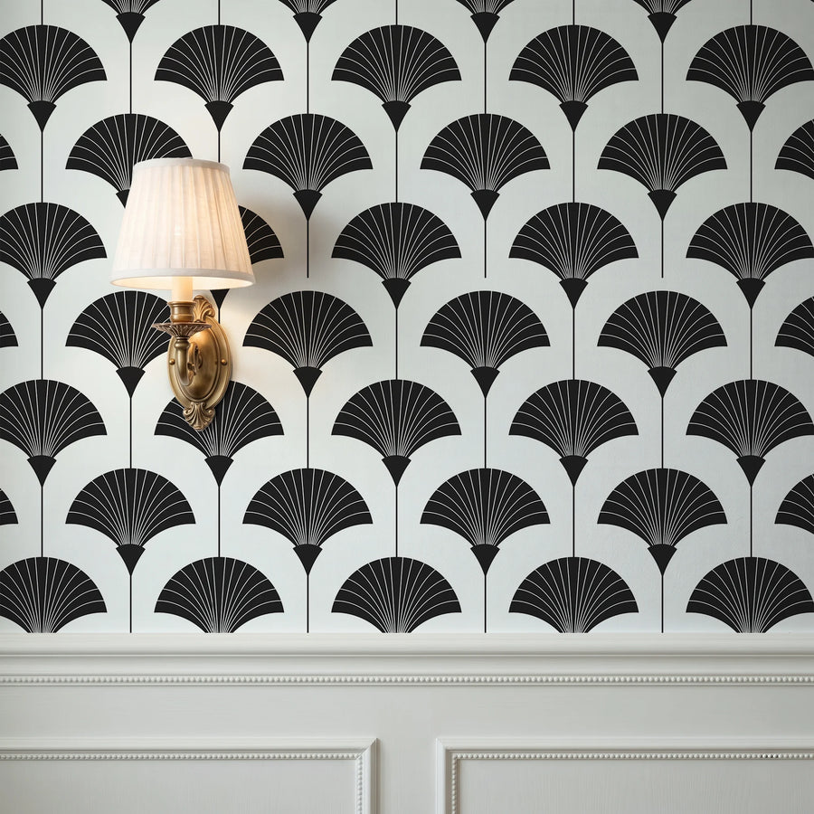 Minimalist black and white Art Deco fan wallpaper on a wall above wainscoting with a brass sconce