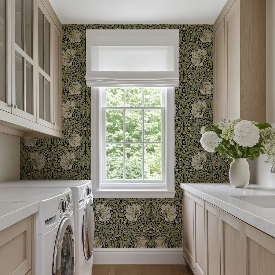 Olive green and cream William Morris Pimpernel wallpaper in a laundry room above cabinets