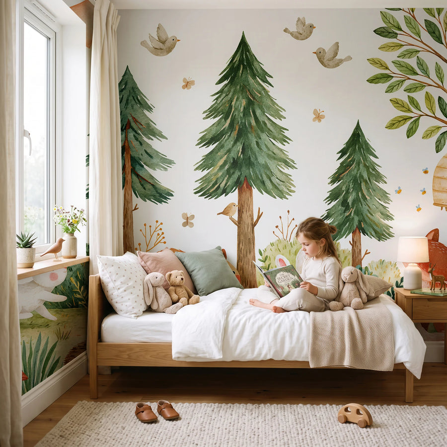 Pine tree and forest animals wall mural in a kids bedroom with a child sitting on the bed