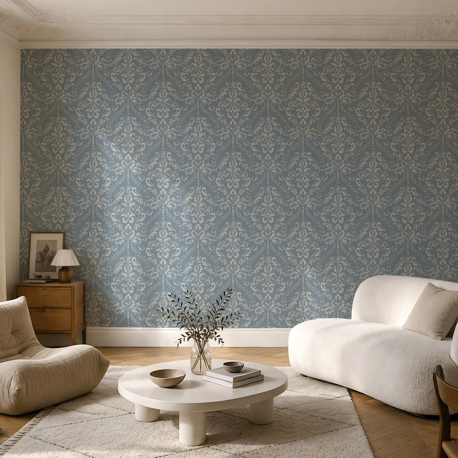 Vintage blue damask wallpaper in a sitting room with a cream chair