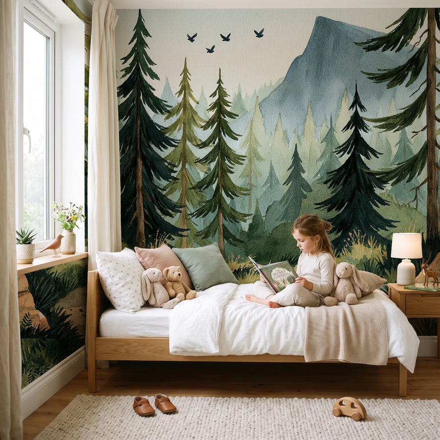 Watercolor mountain forest mural in a kids bedroom with a child sitting on the bed