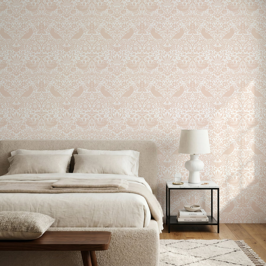 William Morris Strawberry Thief blush pink wallpaper in a bedroom with a low upholstered bed