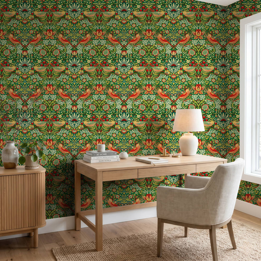 William Morris Strawberry Thief green wallpaper in a study behind a wood desk
